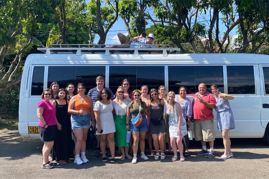 Students and faculty stand in front of a white van in Costa Rica.